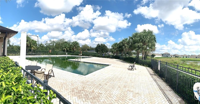 view of swimming pool with a water view and a patio area