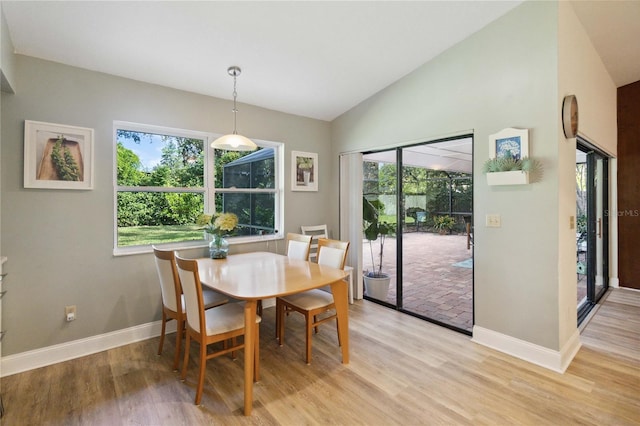 dining area featuring light hardwood / wood-style floors and vaulted ceiling