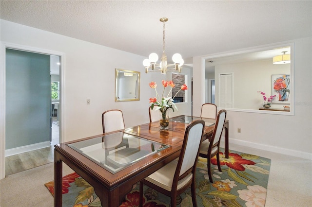 carpeted dining space featuring a textured ceiling and a chandelier