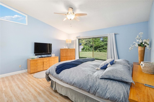 bedroom with ceiling fan, a textured ceiling, wood-type flooring, and vaulted ceiling