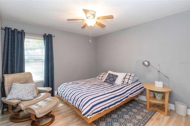 bedroom with hardwood / wood-style floors, a textured ceiling, and ceiling fan