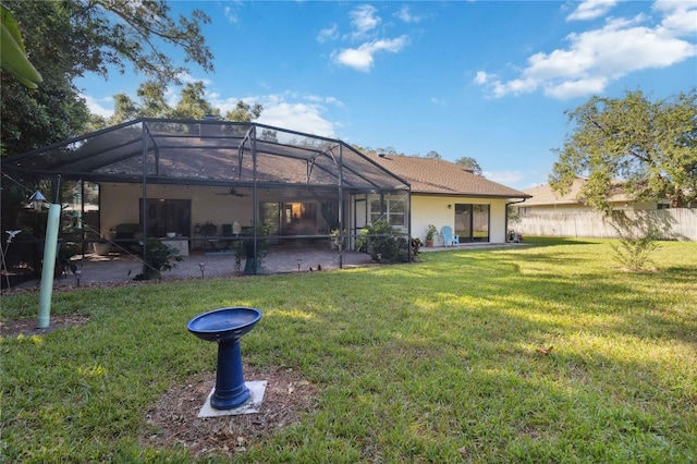 rear view of property featuring a patio area, a lanai, and a lawn