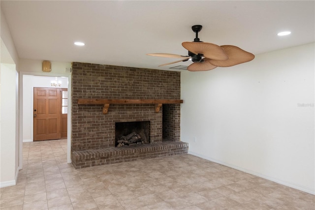 unfurnished living room featuring ceiling fan and a brick fireplace