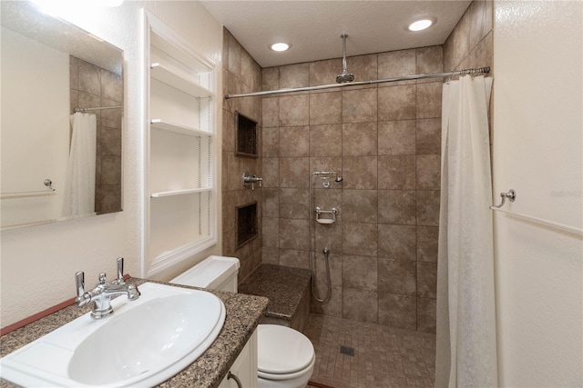 bathroom with toilet, a textured ceiling, vanity, and a shower with shower curtain