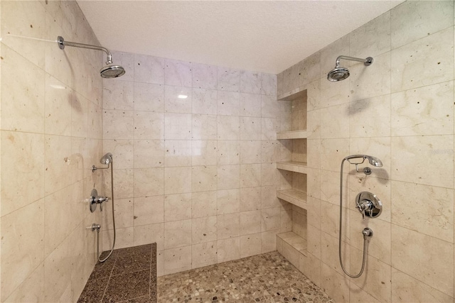 bathroom featuring a tile shower and a textured ceiling