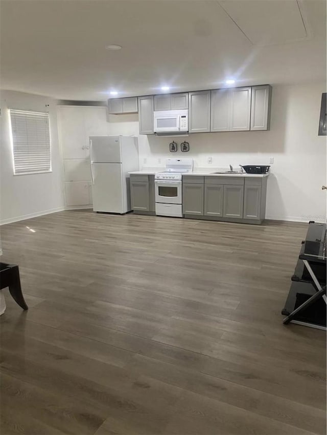 kitchen featuring dark hardwood / wood-style floors, sink, gray cabinetry, and white appliances