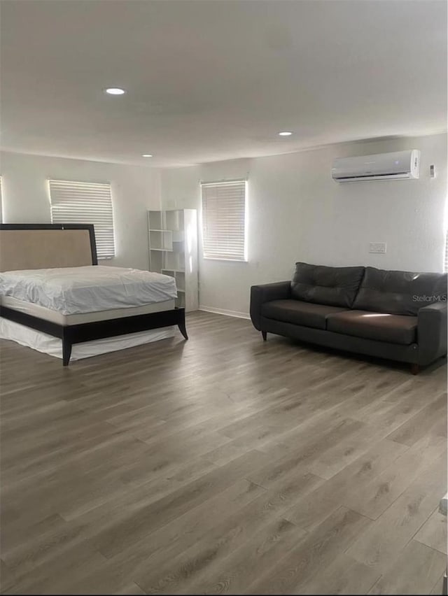 bedroom with hardwood / wood-style flooring and a wall mounted air conditioner