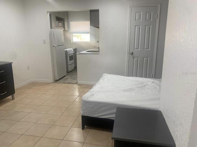 tiled bedroom featuring white fridge and sink