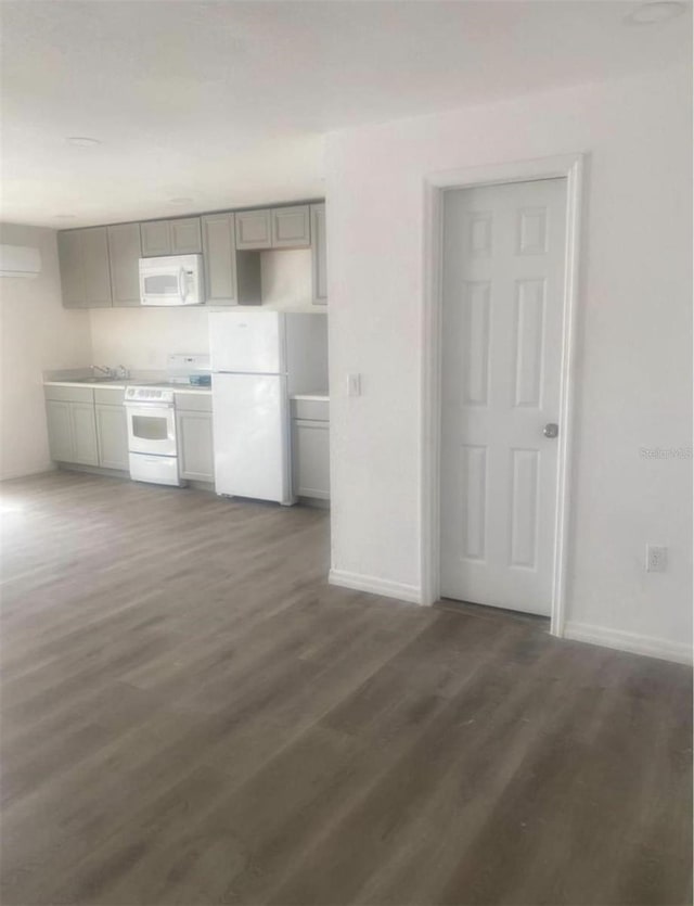 kitchen with white appliances, dark wood-type flooring, sink, and gray cabinets