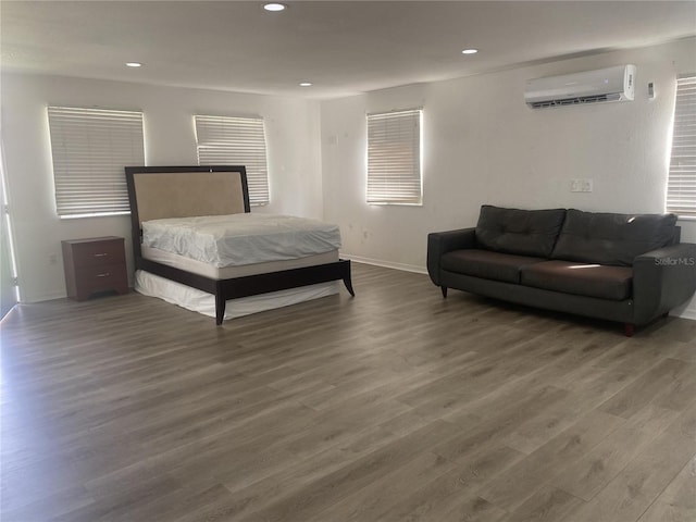 bedroom featuring dark hardwood / wood-style flooring and a wall mounted air conditioner