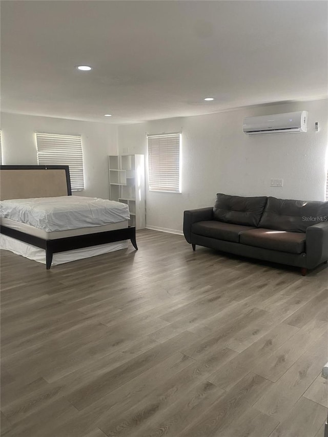 bedroom with a wall unit AC and hardwood / wood-style floors