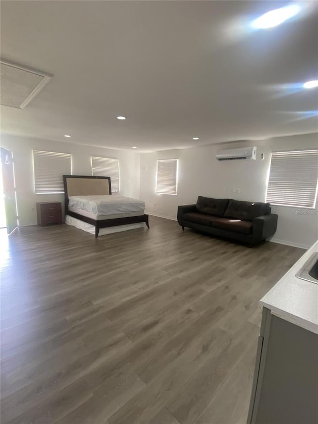 bedroom with an AC wall unit and dark hardwood / wood-style flooring