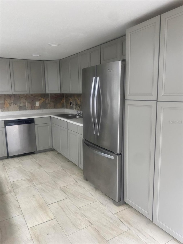 1801 Daniels St, Kissimmee, FL 34746 - kitchen with stainless steel appliances, gray cabinetry, a sink, light countertops, and backsplash