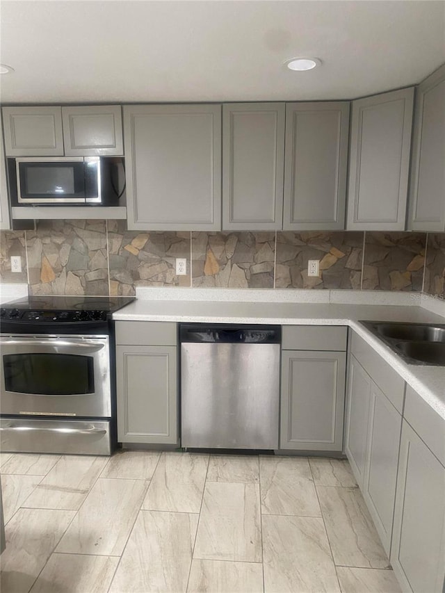 1801 Daniels St, Kissimmee, FL 34746 - kitchen featuring stainless steel appliances, gray cabinetry, backsplash, light countertops, and recessed lighting