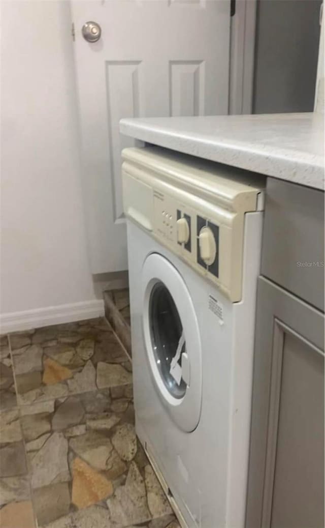 1801 Daniels St, Kissimmee, FL 34746 - laundry room with washer / clothes dryer, stone finish floors, and baseboards