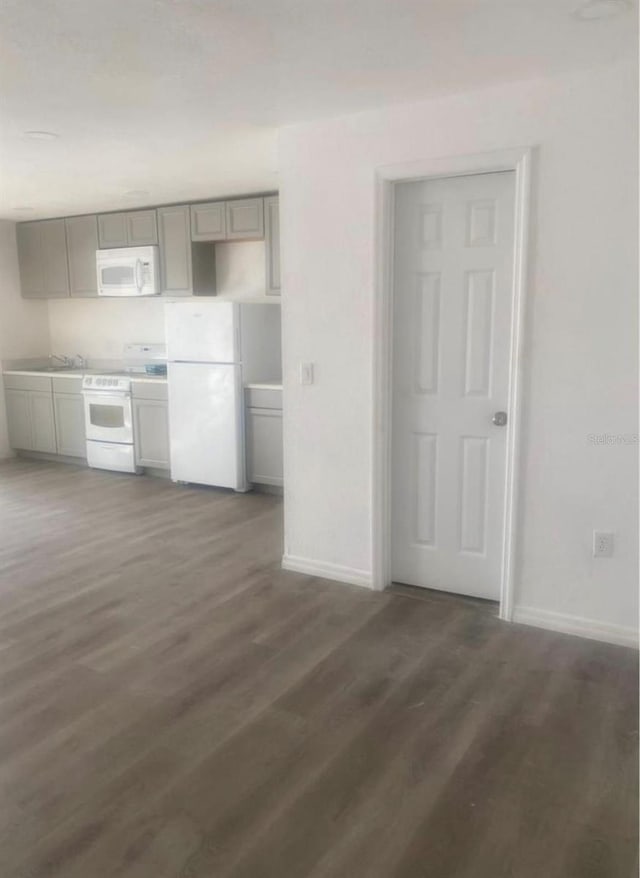 1801 Daniels St, Kissimmee, FL 34746 - kitchen featuring white appliances, gray cabinets, baseboards, wood finished floors, and a sink