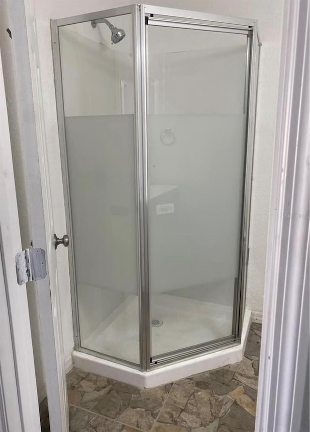 bathroom with a shower with door