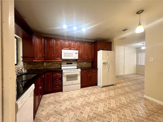 kitchen featuring decorative backsplash, sink, hanging light fixtures, and white appliances