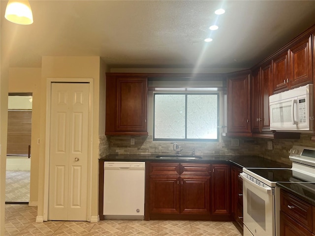 kitchen with white appliances, decorative backsplash, and sink