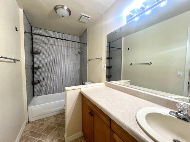 bathroom with tiled shower / bath and vanity