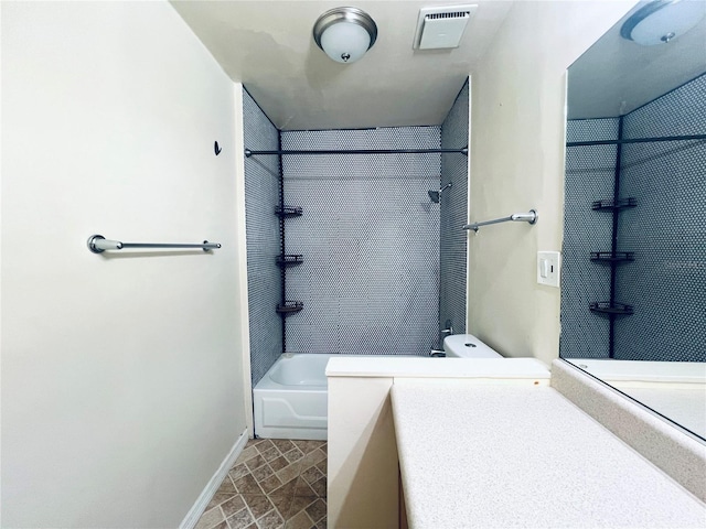 full bathroom featuring tiled shower / bath, vanity, and toilet