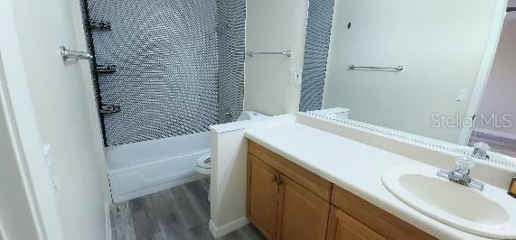 full bathroom with vanity, toilet, wood finished floors, and shower / washtub combination