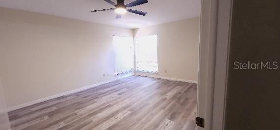 unfurnished room with baseboards, ceiling fan, and wood finished floors