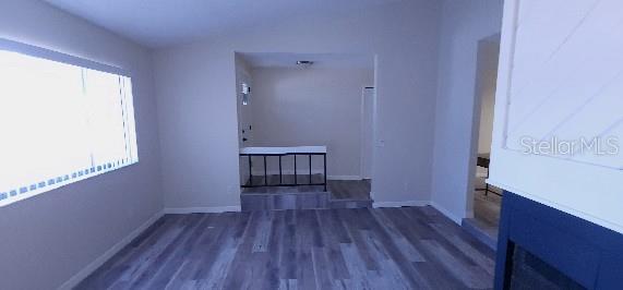 corridor with baseboards and wood finished floors