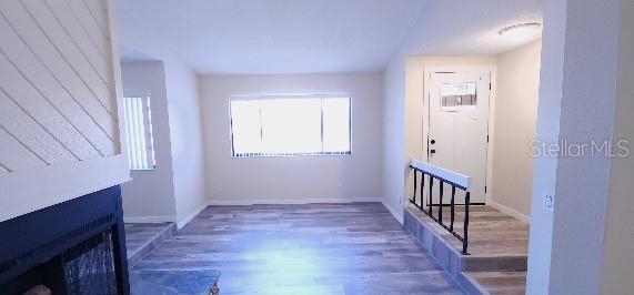corridor featuring baseboards and wood finished floors