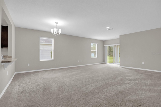 unfurnished room with a notable chandelier and light colored carpet