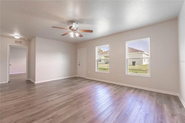 empty room featuring hardwood / wood-style floors, a textured ceiling, and ceiling fan