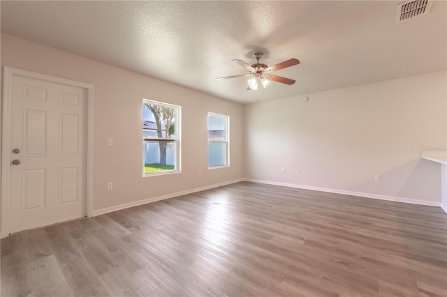 spare room with hardwood / wood-style floors, a textured ceiling, and ceiling fan