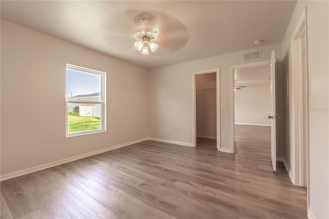 unfurnished room featuring hardwood / wood-style floors, a textured ceiling, and ceiling fan