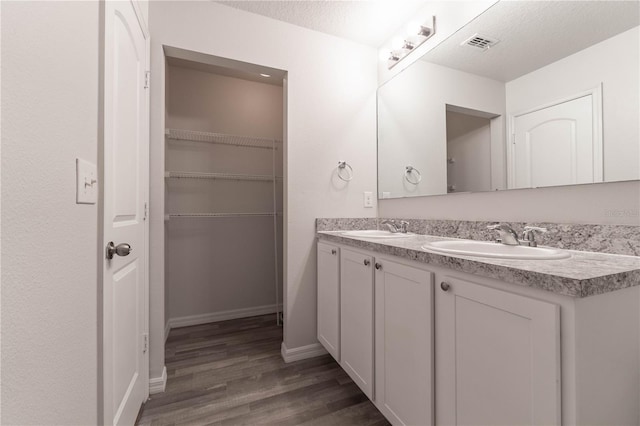 bathroom featuring vanity, a textured ceiling, and wood-type flooring