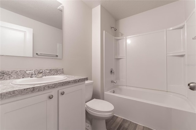 full bathroom with hardwood / wood-style floors, a textured ceiling, toilet, vanity, and shower / bath combination