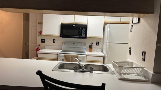 kitchen featuring white cabinetry, white appliances, and sink