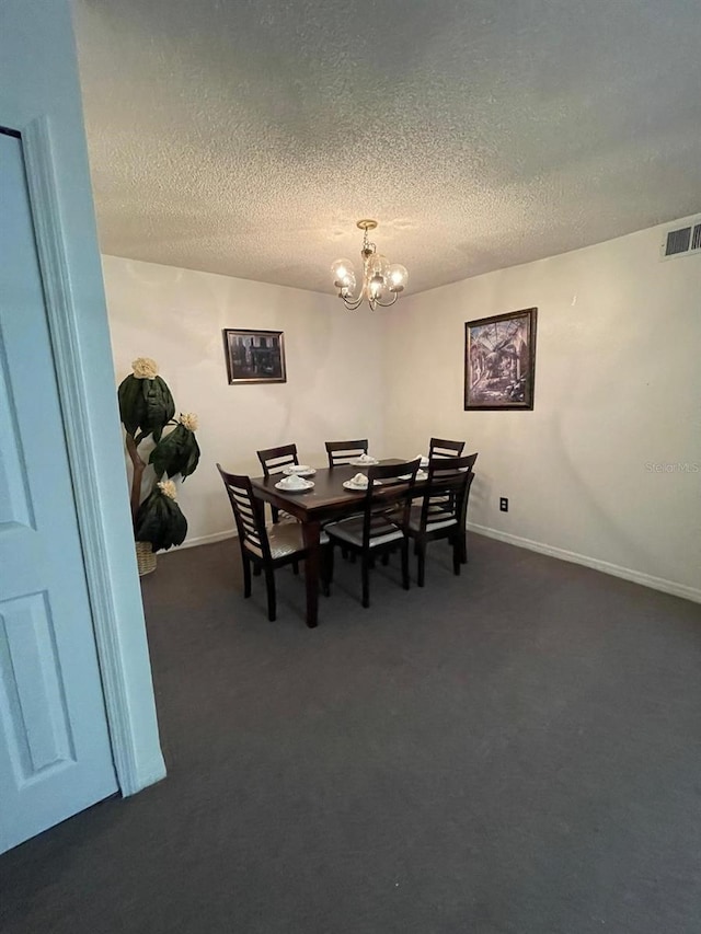 carpeted dining area with a textured ceiling and an inviting chandelier