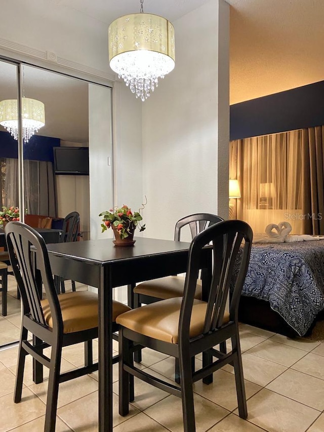 dining space featuring an inviting chandelier and light tile patterned flooring