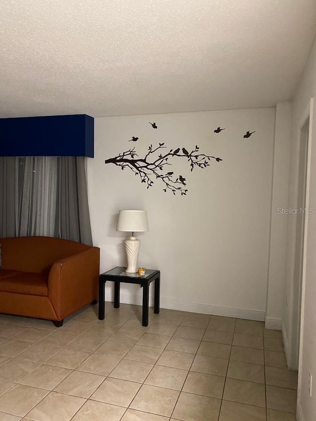 living area with a textured ceiling and light tile patterned floors