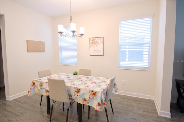 dining area featuring dark hardwood / wood-style flooring and an inviting chandelier