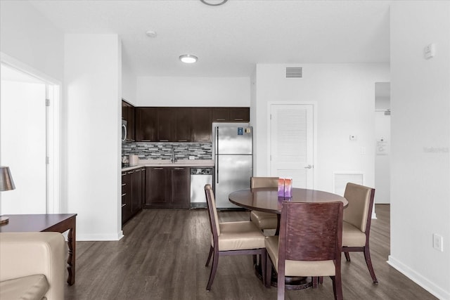 dining room featuring sink and dark wood-type flooring