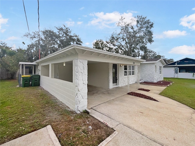 view of front of property featuring a front lawn and a carport