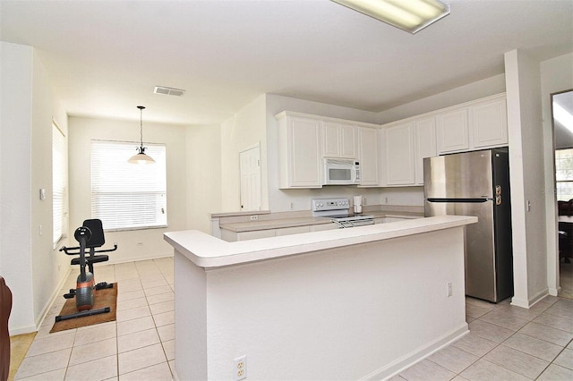 kitchen with white cabinets, decorative light fixtures, white appliances, and light tile patterned flooring