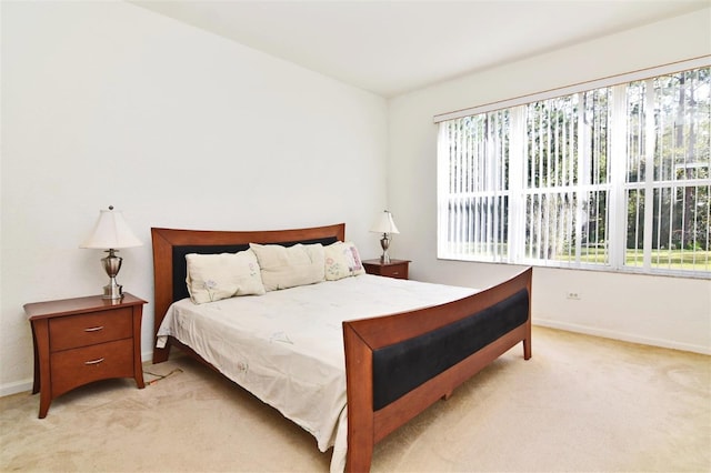 bedroom with multiple windows and light colored carpet