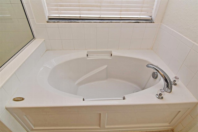 bathroom with a relaxing tiled tub