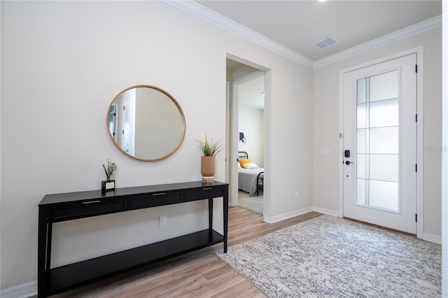 foyer with ornamental molding and light wood-type flooring