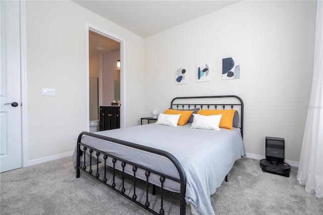 bedroom featuring light colored carpet and ensuite bath