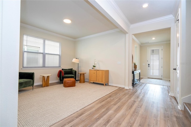 living area with crown molding and light hardwood / wood-style flooring