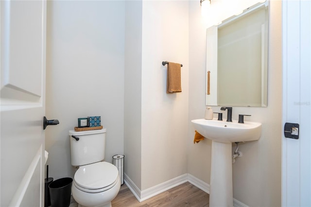 bathroom featuring wood-type flooring and toilet