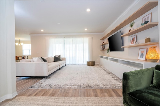 living room with a chandelier, crown molding, and light hardwood / wood-style floors